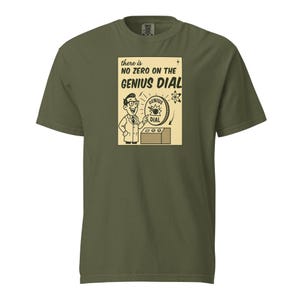 Könnte beinhalten: Olivgrünes T-Shirt mit Retro-Grafik. Die Grafik zeigt einen Cartoon-Wissenschaftler, der auf ein "Genie-Zifferblatt" zeigt, mit dem Text "There is NO ZERO ON THE GENIUS DIAL."