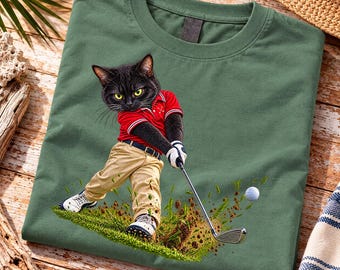 Peut inclure: Un t-shirt vert sauge avec un motif représentant un chat noir portant un polo rouge et un pantalon beige, balançant un club de golf sur un green. Le chat porte des gants et des chaussures de golf blancs, une balle de golf vole en l'air.