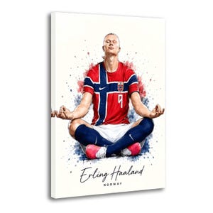 Könnte beinhalten: Ein Leinwanddruck mit einer Illustration im Aquarellstil von Erling Haaland in meditativer Sitzhaltung. Er trägt ein rot-weiß-blaues norwegisches Fußballtrikot mit der Nummer 9, weiße Shorts, blaue Stutzen und pinke Fußballschuhe. Der Text lautet Erling Haaland NORWAY.