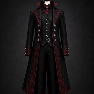 Könnte beinhalten: Ein schwarzer langer Mantel mit roter Blumenstickerei an Revers und Manschetten, kombiniert mit einer gemusterten schwarzen Weste, einem schwarzen Hemd, einem roten Plastron mit zentralem Schmuckstein und einer schwarzen Hose mit Silberknöpfen.