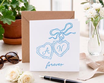 Tarjeta de boda con medallón en forma de corazón y iniciales de pareja personalizadas, tarjeta de felicitación con lazo doble y corazón para siempre dibujado a mano, tarjeta de recuerdo personalizada.