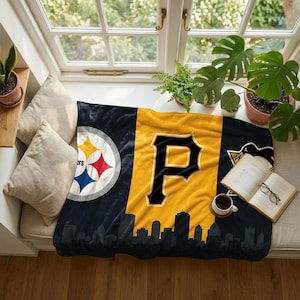 Könnte beinhalten: Eine weiche Fleecedecke in Schwarz und Gold mit dem Logo der Pittsburgh Steelers auf der linken Seite, einem großen schwarzen Buchstaben P in der Mitte und einer schwarzen Silhouette einer Stadtsilhouette am unteren Rand des Stoffes.