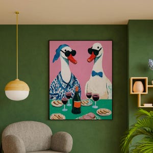 May include: A framed painting depicts two anthropomorphic geese wearing sunglasses, seated at a table with wine and food. The geese are set against a pink background, with a green tablecloth. The painting has a whimsical and artistic style.