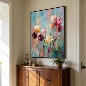 May include: A framed floral painting featuring tulips in shades of pink, yellow, and burgundy against a colorful background. The artwork hangs above a wooden cabinet with decorative vases and a potted plant.