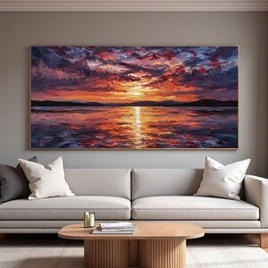 Könnte beinhalten: Ölgemälde eines Sonnenuntergangs über dem Wasser. Der Himmel ist mit kräftigen Pinselstrichen in Rot, Orange und Lila gemalt. Das Wasser spiegelt die Farben des Sonnenuntergangs wider und erzeugt eine eindrucksvolle und farbenfrohe Landschaft. Das Gemälde ist gerahmt.
