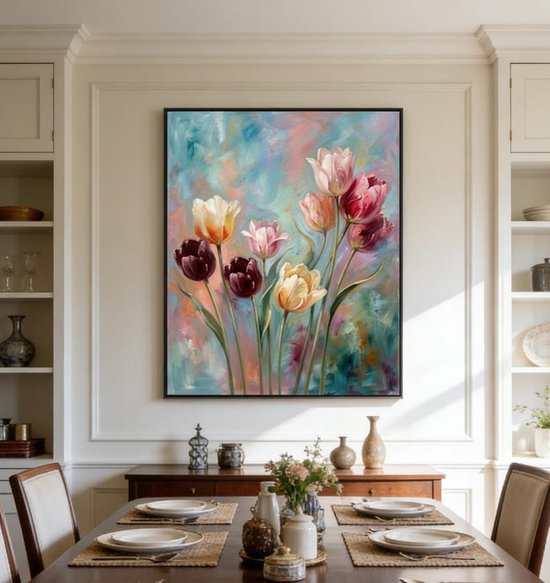 May include: A framed floral painting featuring colorful tulips in shades of pink, yellow, and burgundy against a soft, blended background of blue, pink, and peach. The artwork is displayed above a wooden dining table.