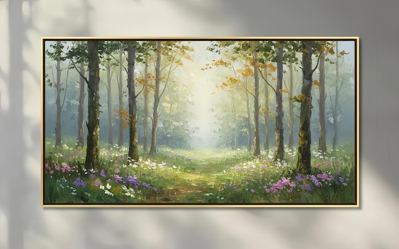 May include: A rectangular landscape painting in a thin gold frame depicting a sunlit forest clearing. Tall tree trunks rise from a grassy floor covered in patches of white and purple wildflowers, with soft light filtering through the canopy.