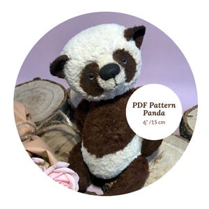 May include: A soft toy panda bear in brown and white, with a black nose and dark eyes. The text "PDF Pattern Panda 6" / 15 cm" is visible on the image. The panda measures approximately 15 cm in height.