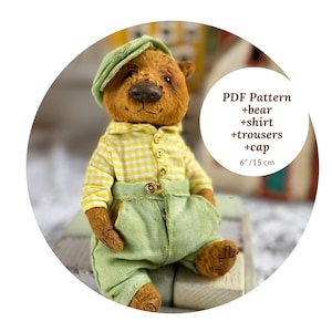 Pode incluir: Um urso de pelúcia castanho feito à mão, vestindo uma camisa xadrez amarela, calças verdes e um boné verde. O urso tem aproximadamente 15 cm de altura. A imagem inclui o texto "PDF Pattern +bear +shirt +trousers +cap 6"/15 cm."