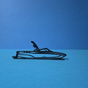 May include: A black outline of a speedboat with a sleek design. The boat has a curved hull, a raised windshield, and a small structure at the back. The background is a solid blue.