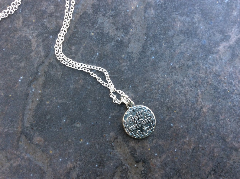 May include: Silver necklace with a round pendant that says "Gott mit dir" in a decorative font.