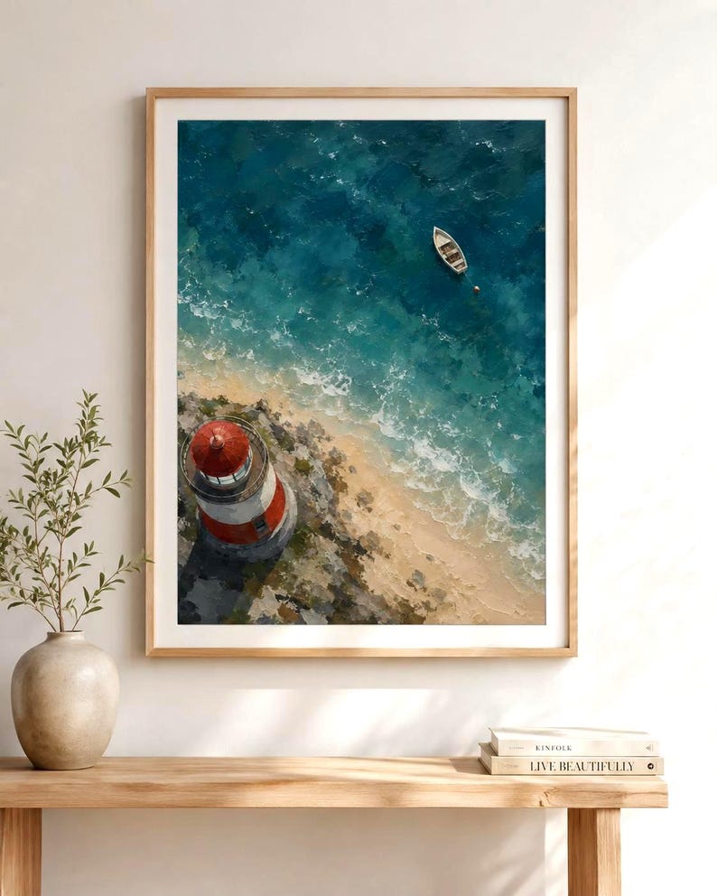 May include: A framed wall art print featuring an aerial view of a red and white lighthouse on a rocky coastline with a small white boat floating in the deep blue ocean water. The artwork displays textured brushstrokes and a coastal landscape scene.