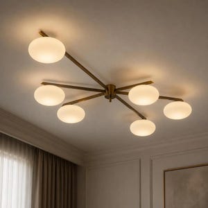 Może przedstawiać: Lampa sufitowa z centralnym mosiężnym korpusem i sześcioma rozchodzącymi się ramionami. Każde ramię zakończone jest okrągłym kloszem z matowego białego szkła, który emituje miękkie, ciepłe światło, zapewniając zrównoważone, wielokierunkowe oświetlenie.
