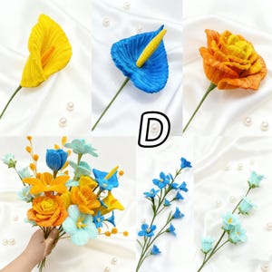 May include: A collection of colorful, handmade fabric flowers. The image showcases a yellow calla lily, a blue anthurium, and an orange rose. Additional arrangements include a bouquet and several stems of blue and light blue flowers.