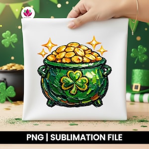 Puede incluir: Cojín cuadrado blanco con una olla de oro verde con diseño de trébol, monedas de oro y detalles de estrellas. El texto "PNG | SUBLIMATION FILE" está en la parte inferior. El cojín está sostenido por una mano.