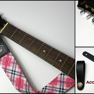 Pu&ograve; includere: Tracolla per chitarra acustica con motivo a quadri rosa, bianco e nero. La tracolla ha estremit&agrave; in pelle nera con una rivetto a forma di stella. La paletta della chitarra &egrave; nera con meccaniche argentate.