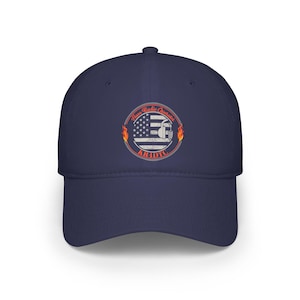 May include: Navy blue baseball cap with a circular emblem reading "Ham Radio Operator" and "K1UDC". The emblem features an American flag design, a radio, and flames. The cap is made of a robust fabric.