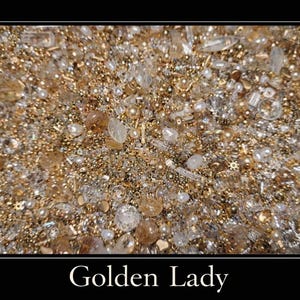 May include: Close-up of a textured surface with a mix of gold, clear, and pearl-colored beads and embellishments. The image has a warm, shimmering effect, with the text "Golden Lady" at the bottom. The overall theme is jewelry or decorative art.