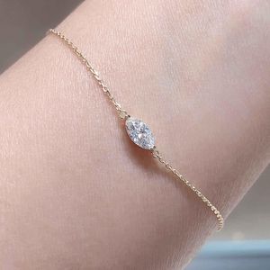 Puede incluir: Una delicada pulsera de oro con un diamante talla marquesa. El diamante es el punto focal, engastado en un diseño minimalista. La cadena de la pulsera es fina y añade un toque de elegancia a la joya.