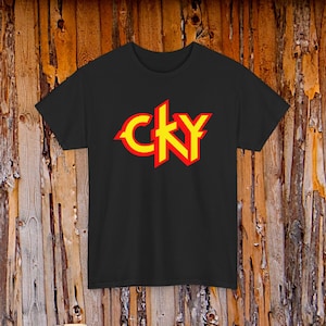 May include: Black t-shirt featuring the text "CKY" in a stylized design. The letters are outlined in red with a yellow fill. The shirt is made of a soft material and is suitable for casual wear.