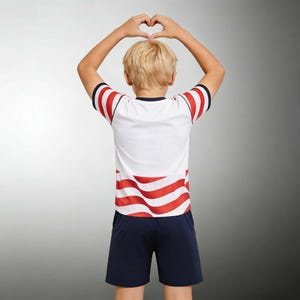May include: A white and red striped t-shirt and navy blue shorts set. The t-shirt has red stripes on the sleeves and lower portion. The person is making a heart shape with their hands.