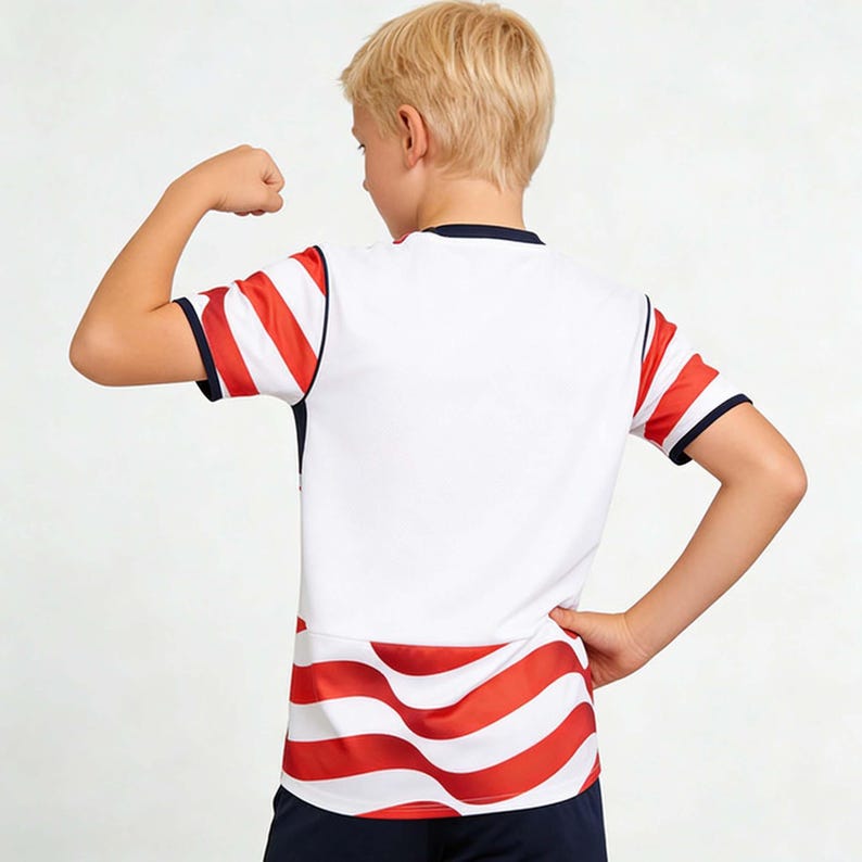 May include: White athletic shirt with red and white striped sleeves and a red and white striped bottom. The shirt has a navy blue trim and is worn by a person.