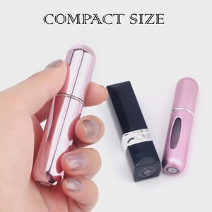 Puede incluir: Un atomizador de perfume rosa y plateado, una barra de labios negra y un segundo atomizador rosa. El texto "COMPACT SIZE" est&aacute; encima de los objetos.