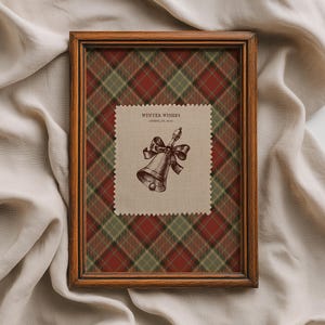 Può includere: Una stampa incorniciata a tema festivo. La cornice in legno circonda un motivo a quadri rosso, verde e marrone. All'interno, un quadrato beige presenta un'illustrazione di campana con un fiocco e il testo "WINTER WISHES".