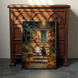 May include: A framed rectangular wall art print depicting a scene of two figures in costumes walking up stone steps toward a house entrance at night, surrounded by glowing orange jack-o'-lanterns, autumn foliage, and warm yellow light from windows.