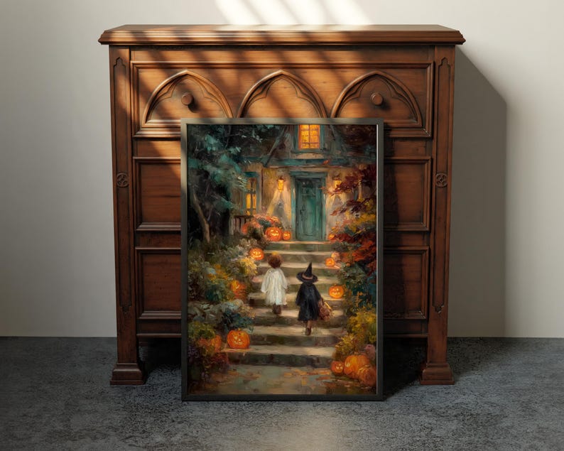 May include: A framed rectangular wall art print depicting a scene of two figures in costumes walking up stone steps toward a house entrance at night, surrounded by glowing orange jack-o'-lanterns, autumn foliage, and warm yellow light from windows.