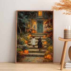 May include: A framed wall art print depicting a nighttime scene of two children in costumes walking up stone steps toward a house entrance. The path is lined with glowing orange pumpkins, autumn foliage, and warm yellow light from the house windows.