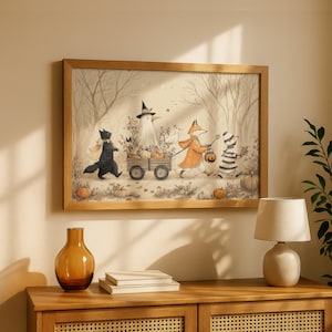 May include: A framed wall art print featuring a whimsical autumn scene with a black cat, a bird in a witch hat, a fox in an orange coat, and a striped creature pulling a wooden wagon filled with pumpkins through a forest of bare trees.