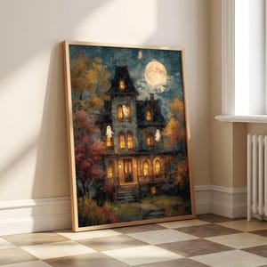 May include: A framed vertical wall art print depicting a multi-story Victorian house at night with glowing yellow windows, surrounded by autumn trees with orange and red foliage, under a large full moon with several small white ghost figures.