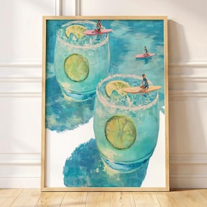 Könnte beinhalten: Ein gerahmter Kunstdruck mit zwei türkisfarbenen Cocktails in Gläsern, jeweils garniert mit einer Limettenscheibe. Winzige Figuren surfen auf rosa und beigen Surfbrettern auf der Oberfläche der Getränke vor einem hellblauen Hintergrund.