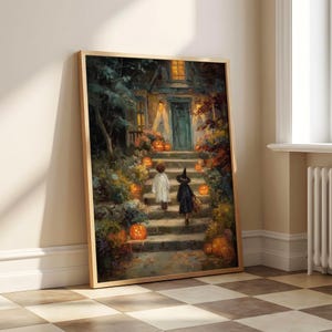 May include: A framed wall art print depicting a nighttime scene of two figures in costumes walking up stone steps toward a house entrance. The scene is illuminated by glowing orange jack-o'-lanterns and warm yellow lights from the house windows.