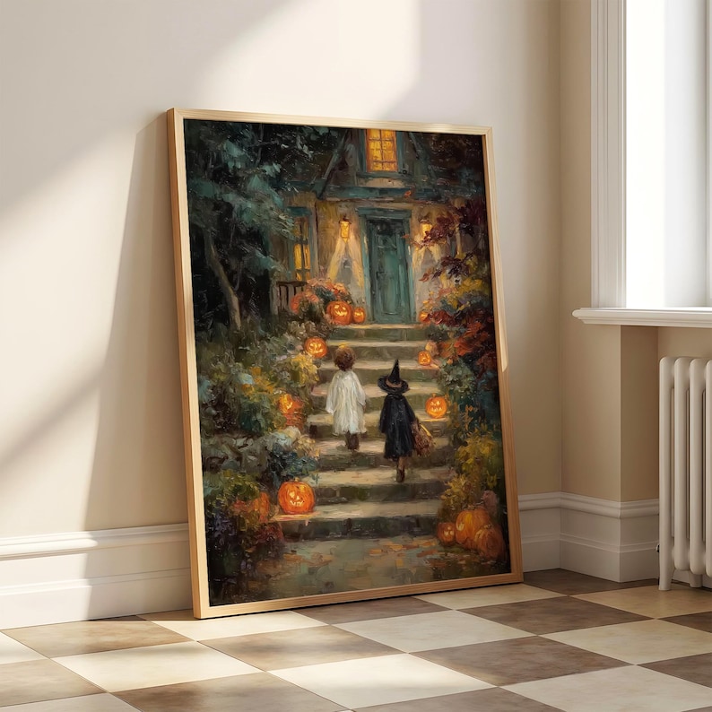 May include: A framed wall art print depicting a nighttime scene of two figures in costumes walking up stone steps toward a house entrance. The scene is illuminated by glowing orange jack-o'-lanterns and warm yellow lights from the house windows.