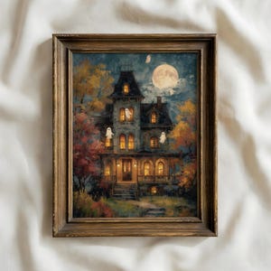 May include: A framed wall art print depicting a multi-story Victorian house at night with glowing yellow windows, surrounded by autumn trees in shades of orange and red, under a large full moon with several small white ghosts floating around.