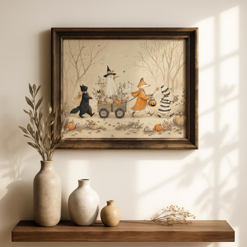 May include: A framed wall art print featuring a whimsical illustration of a black cat, a ghost in a witch hat, a fox in an orange coat, and a child in a striped costume pulling a wooden wagon filled with pumpkins through a forest.