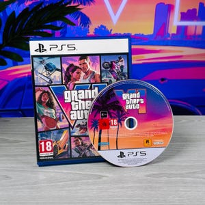 May include: A PlayStation 5 video game case and disc for Grand Theft Auto VI. The cover art features a collage of characters, a helicopter, a motorcycle, and a yellow sports car with the title text. The disc displays a sunset palm tree graphic.