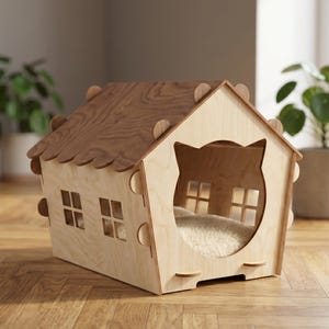 May include: A wooden cat house shaped like a house with a cat-shaped opening. The roof is a darker wood, and the walls are a lighter wood. The house has small square windows and a soft, fluffy interior. The cat house is on a wooden floor.