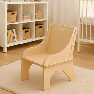 May include: A light-colored wooden toddler nursery chair. The chair is made of 12mm Baltic Birch Plywood and features a curved back and armrests. The chair is designed for children aged 1-3 years old.