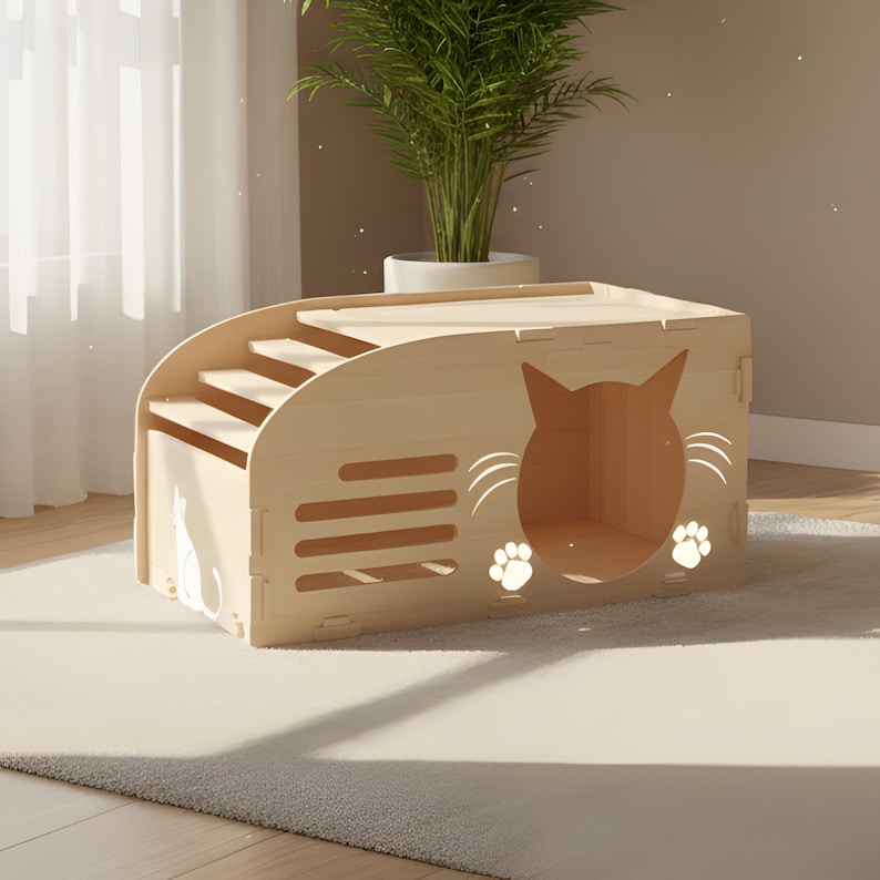 Puede incluir: Una casa para gatos de madera clara con una escalera incorporada y una entrada en forma de gato. El dise&ntilde;o incluye una silueta de gato y huellas de patas. La estructura est&aacute; colocada sobre una alfombra de color claro.