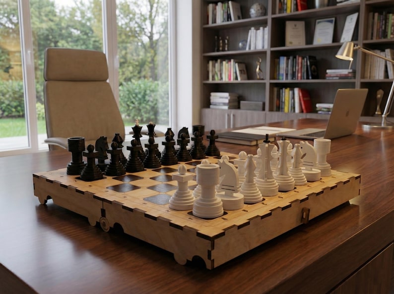 May include: A wooden chess set with black and white pieces arranged on a checkered board. The board is set on a dark wooden desk in a well-lit room. The chess pieces are in their starting positions.