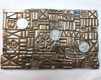 Más de 175 mosaicos de cerámica artesanales, de diversas formas, texturas y tamaños, con tonos metálicos dorados viejos. Materiales de arte esmaltados.
