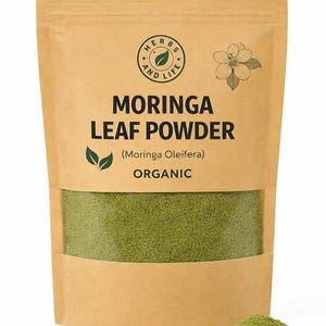 May include: A brown paper packet of organic moringa leaf powder. The packet has a clear window displaying the green powder. Text on the packet reads "Moringa Leaf Powder" and "Organic". A circular logo and a flower graphic are also visible.