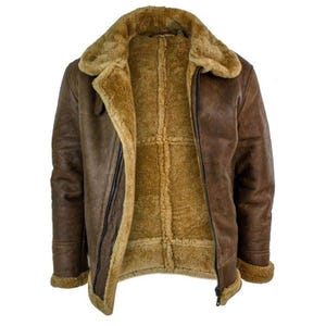 Puede incluir: Chaqueta de cuero marrón con forro y cuello de borrego. La chaqueta tiene cierre de cremallera y un estilo aviador clásico. El interior es de color beige cálido, contrastando con el exterior marrón oscuro. La chaqueta tiene un cuello y puños anchos.