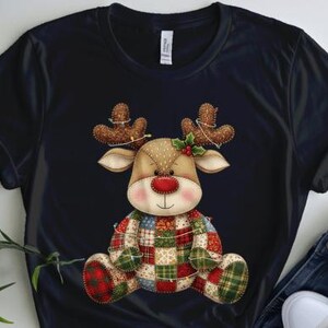 以下が含まれることがあります： 黒いTシャツに、漫画のトナカイのデザイン。トナカイはパッチワークの体、茶色の角、赤い鼻をしており、ヒイラギとライトが付いています。Tシャツは青いジーンズと白いスニーカーと組み合わせています。