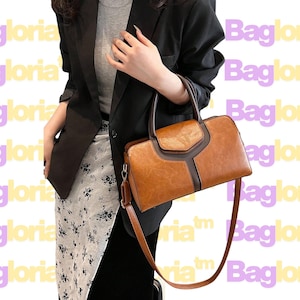 Puede incluir: Bolso de mano de cuero marrón con asa superior y bandolera extraíble. El bolso tiene forma rectangular con cierre de solapa y detalles en marrón oscuro. La palabra "Bagloria" se repite en el fondo.