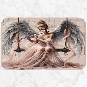 May include: A digital art print of an angel playing a flute while seated on a swing. The angel wears a flowing pink gown and has large, feathered wings. The background features musical notes.