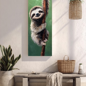 Puede incluir: Pintura vertical de un perezoso sonriente agarrado a una rama marrón sobre un fondo verde. El perezoso tiene pelaje marrón y blanco y mira directamente al espectador. La pintura se exhibe en una pared blanca.
